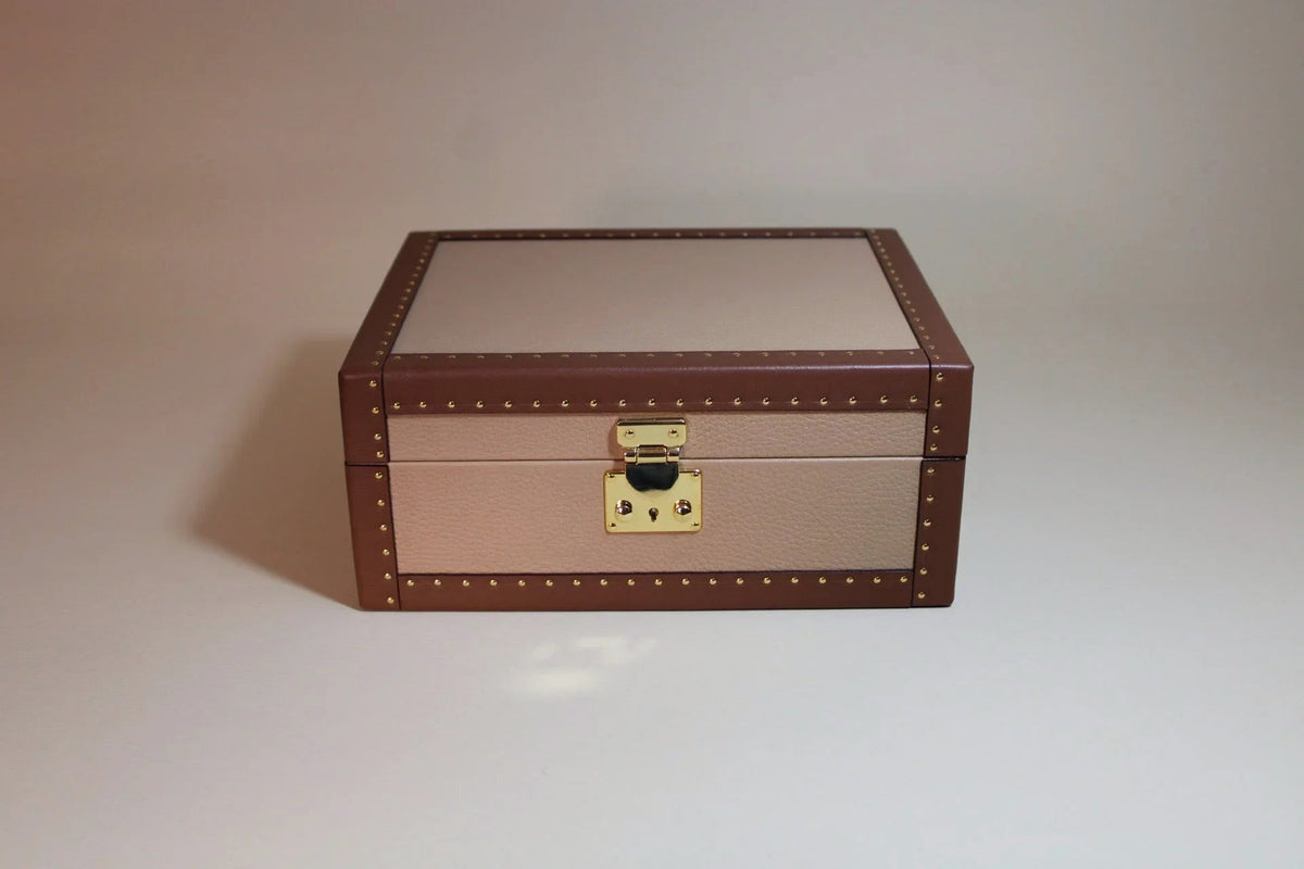 Handcrafted brown and beige leather trunk with gold stud accents and metal clasp