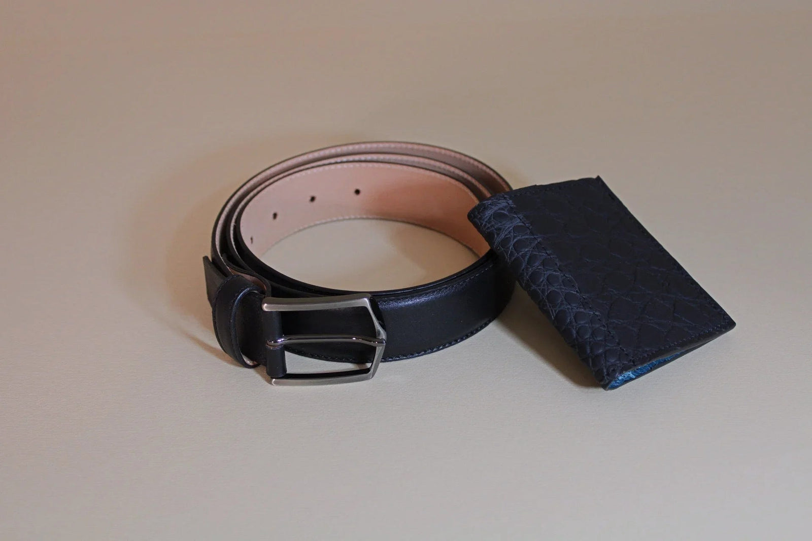 Black leather belt with silver buckle and textured navy leather card holder