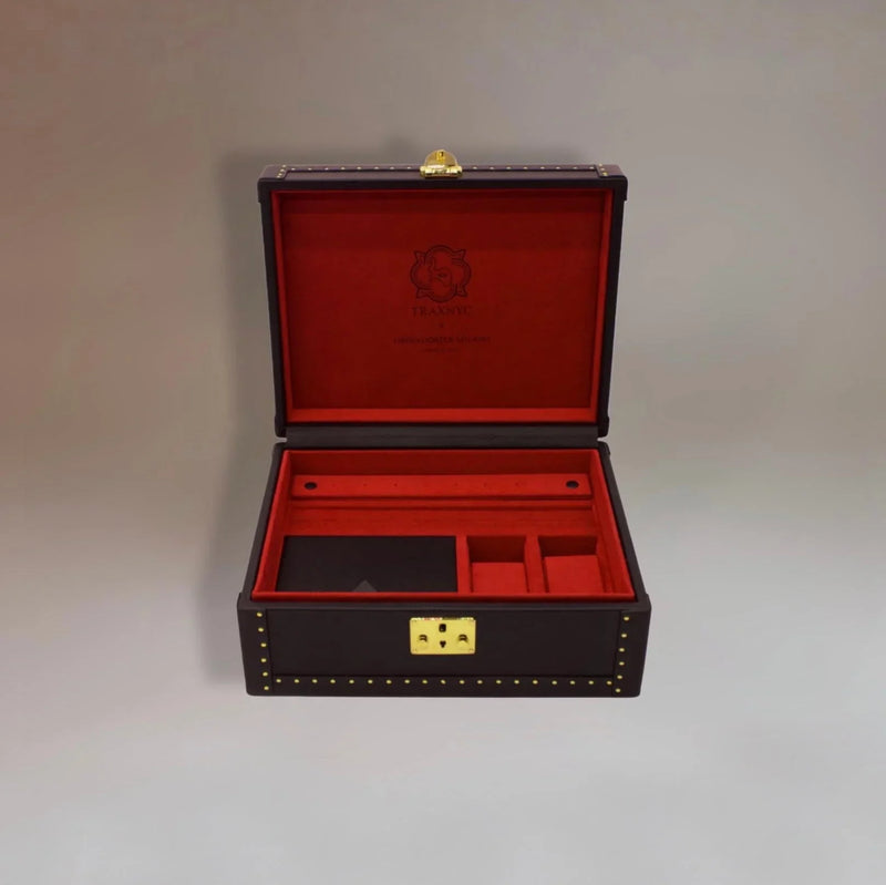 Open luxury leather jewelry box with red velvet interior and gold hardware compartments