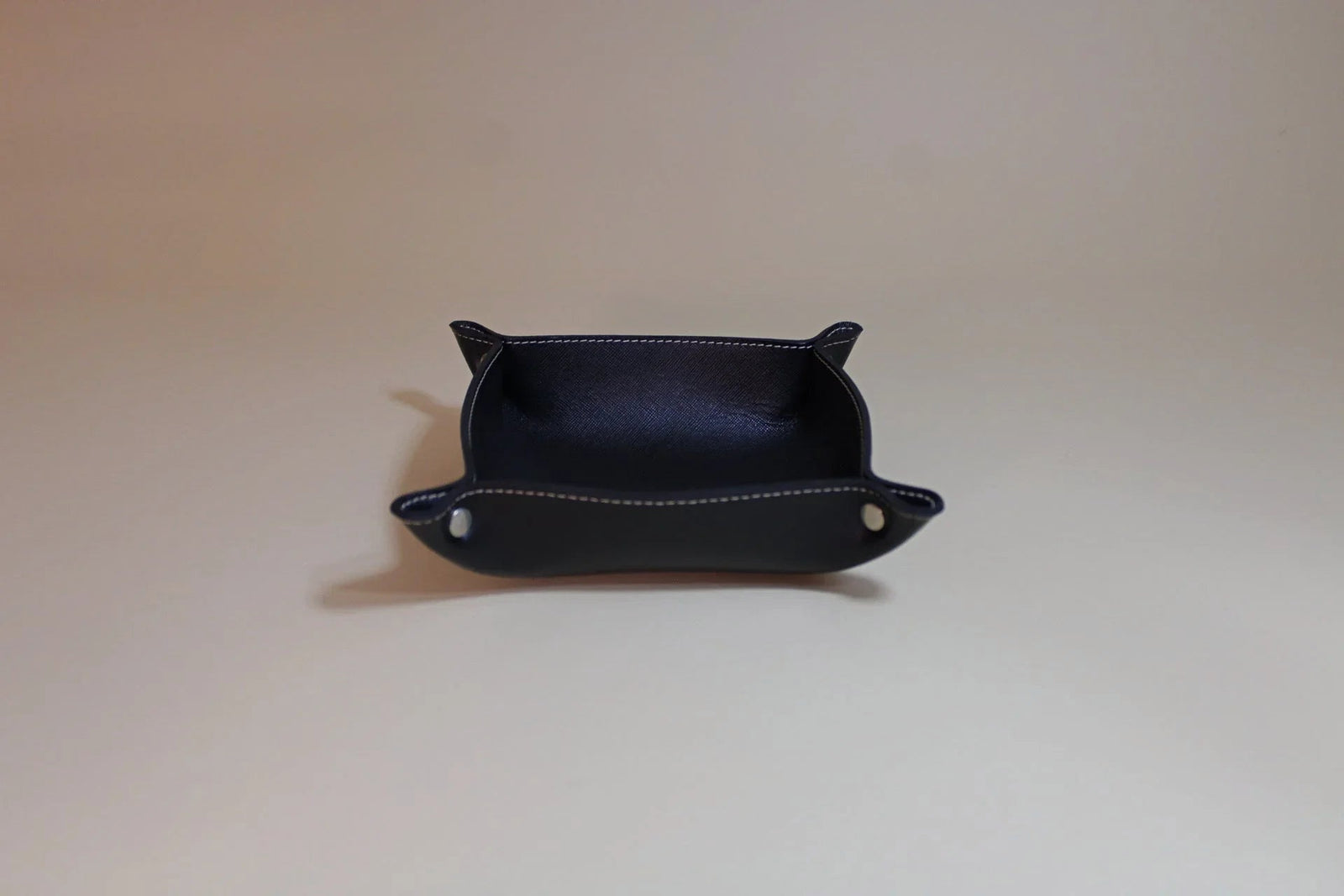 Black leather valet tray with white stitching