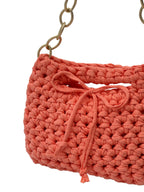Peach crochet handbag close-up showing woven texture and tie closure