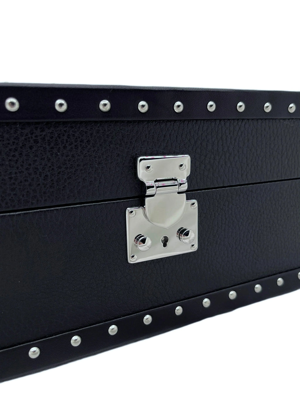 Close-up of black textured leather box with silver studs and polished metal latch