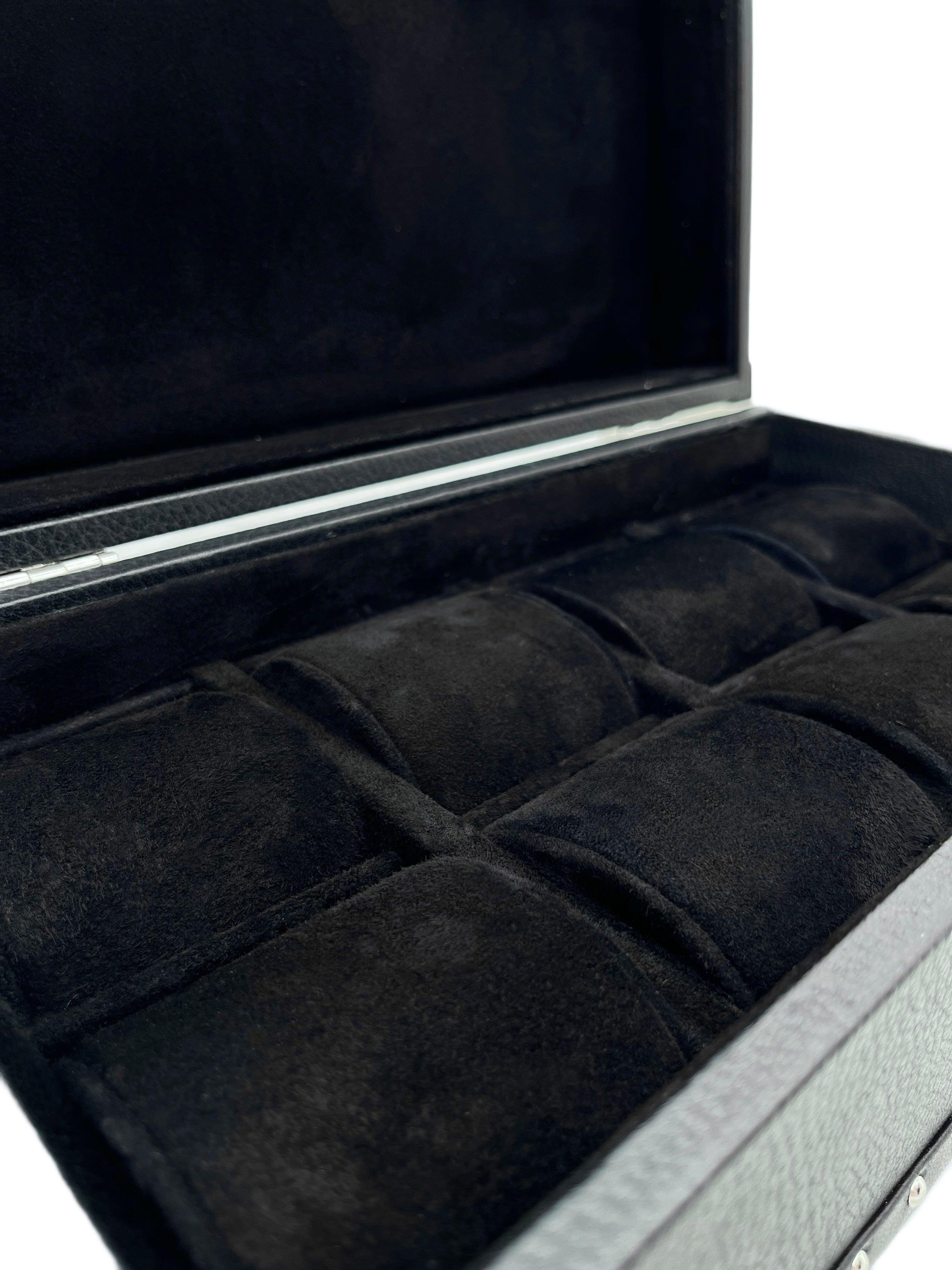 Open black leather watch box with soft velvet compartments for storage