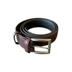 Brown leather belt coiled showing metal buckle
