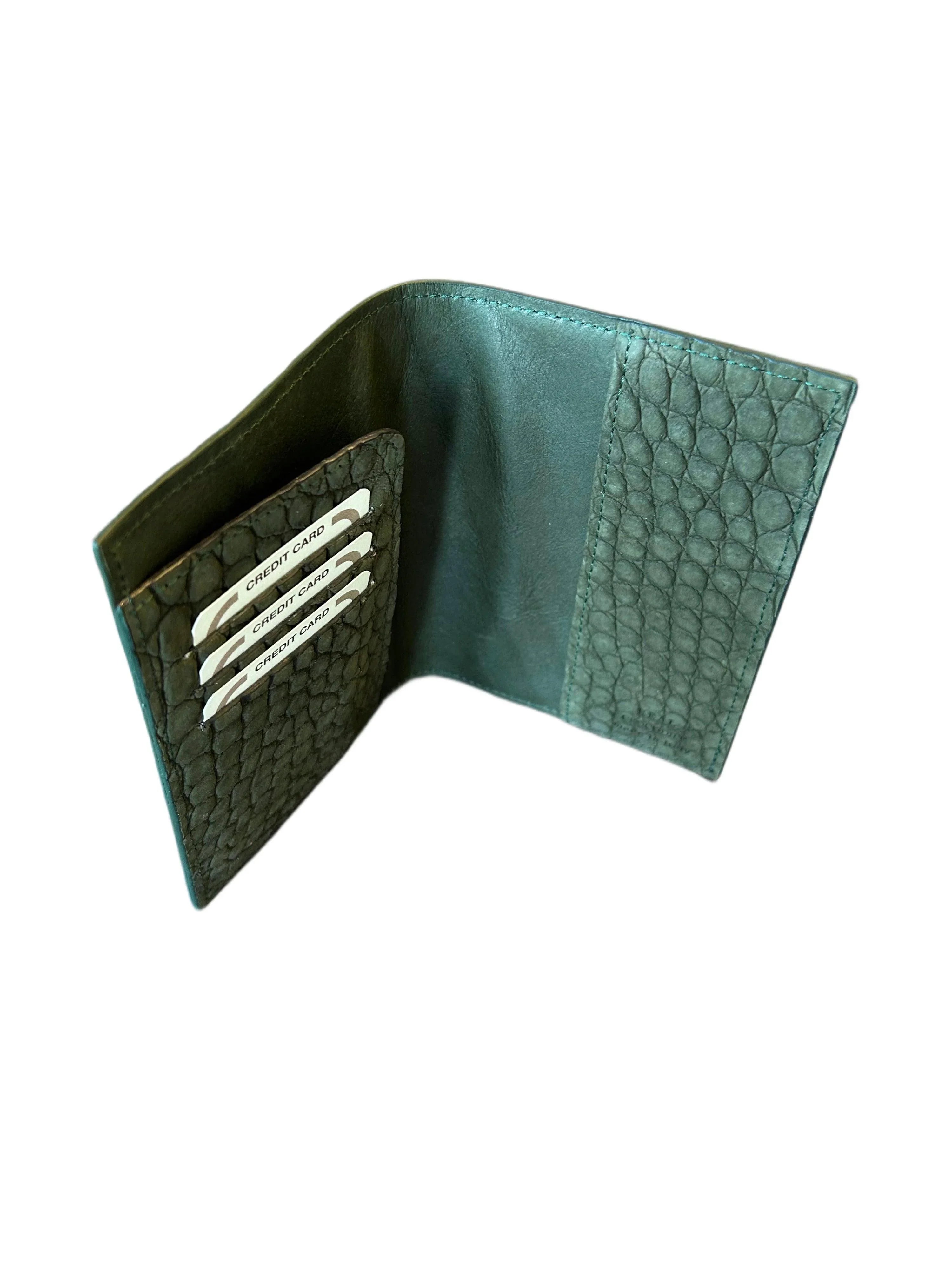 Open green textured leather wallet with card slots, handcrafted luxury accessory