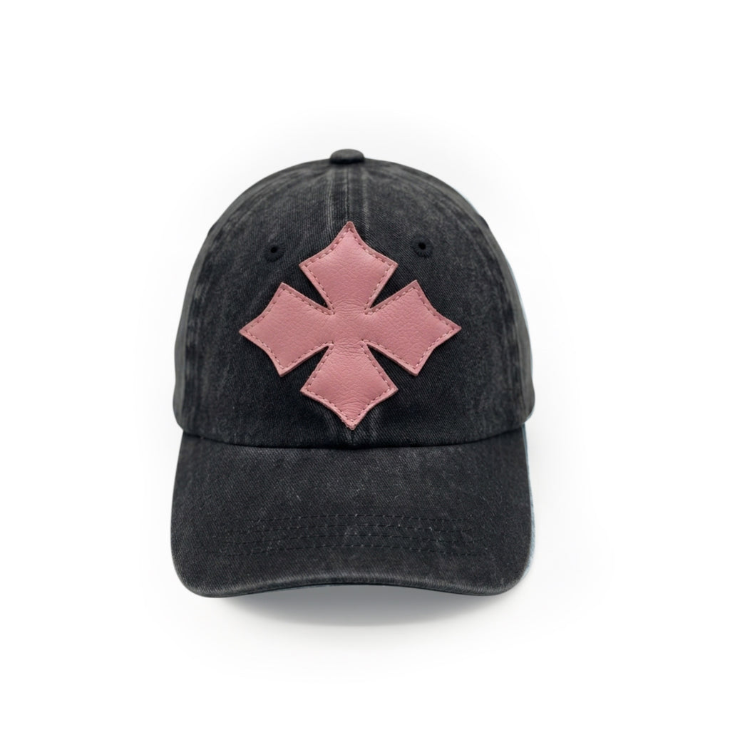 Front view of a black washed cotton six-panel baseball cap with the Oberndörfer Milano logo cut from pink calf leather