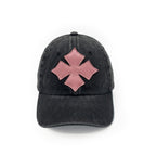 Front view of a black washed cotton six-panel baseball cap with the Oberndörfer Milano logo cut from pink calf leather