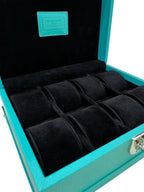Turquoise leather luxury watch box with black velvet interior and multiple compartments.