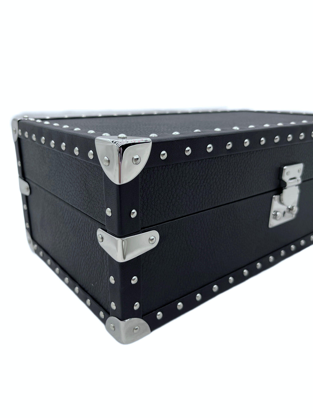 Black leather luxury storage box with silver metal studs and corner hardware, close-up view