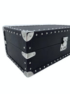 Black leather luxury storage box with silver metal studs and corner hardware, close-up view