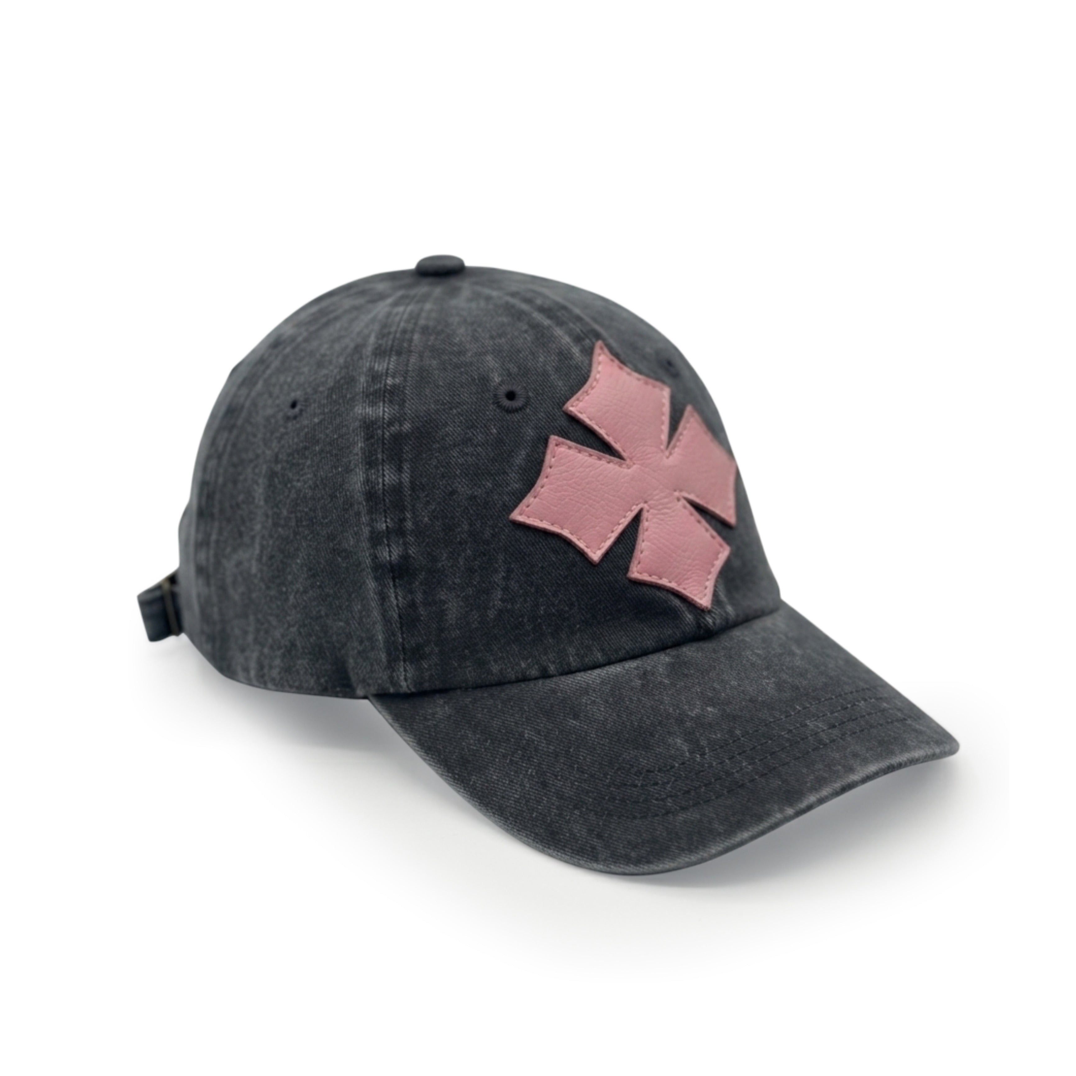 Three-quarter view of the black washed cotton cap showing the pink calf leather logo patch and crown seams