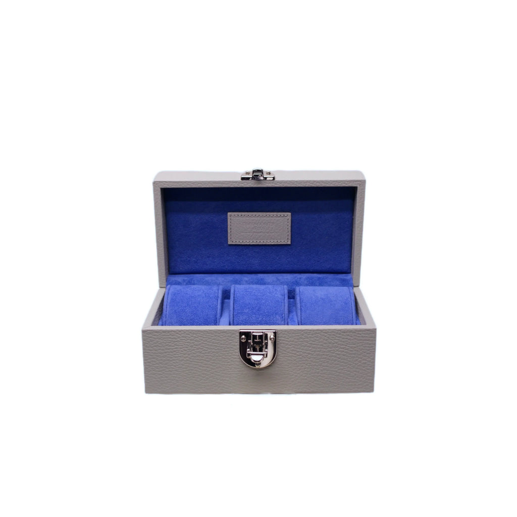 Handcrafted grey leather watch box with blue velvet interior and metal clasp, open and empty.