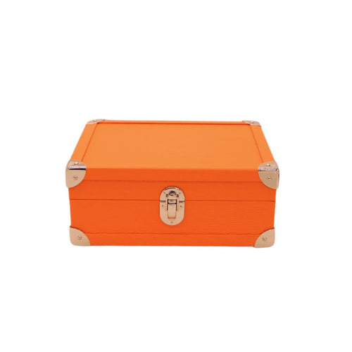 Orange handcrafted leather box with metal corners and latch on white background