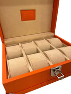 Luxury orange leather watch box with beige suede interior and metal clasp