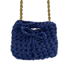 Blue mini crochet handbag styled on shoulder with gold chain strap