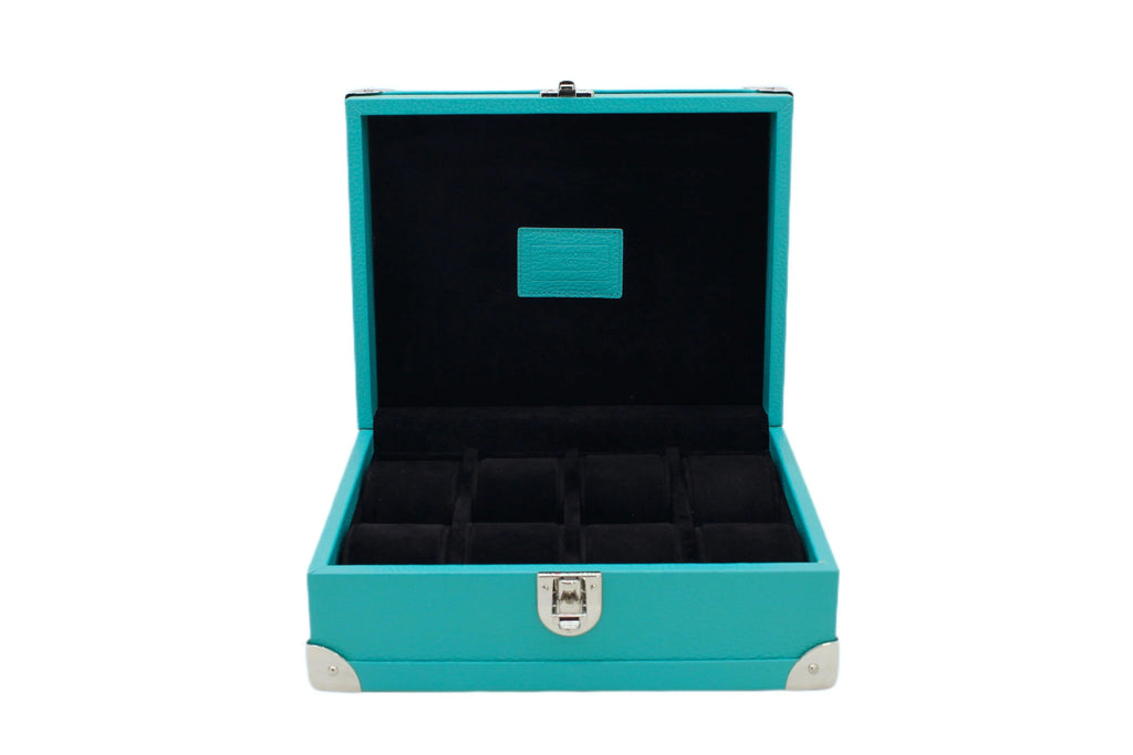 Open turquoise leather watch box with black velvet interior and compartments