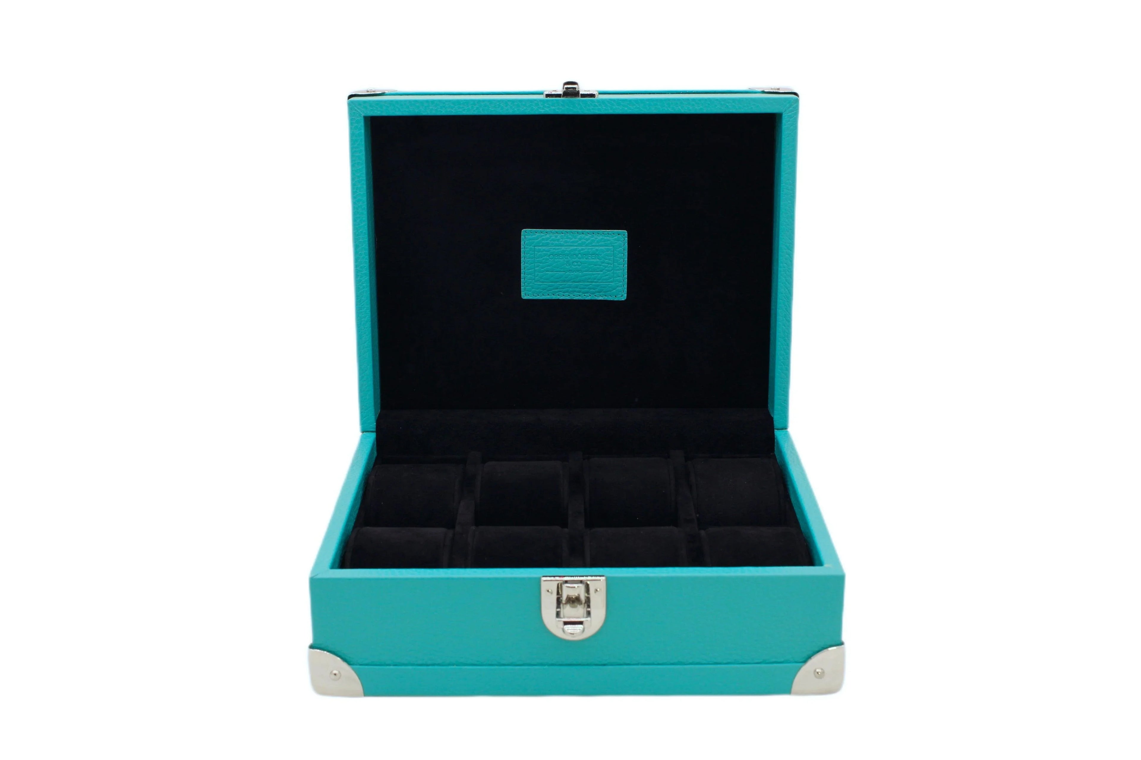 Open turquoise leather watch box with black velvet interior and compartments