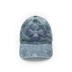 Three-quarter view of the blue washed cotton cap showing the calf leather logo patch and crown seams