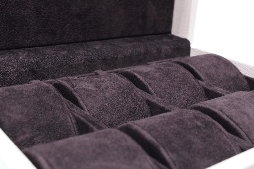 Close-up of a luxury suede-lined watch storage case with multiple compartments