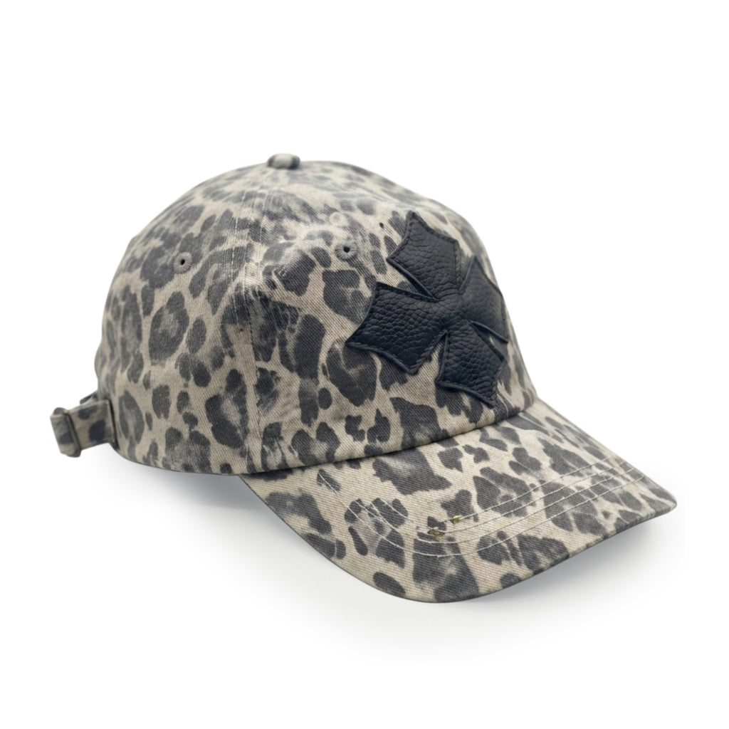 Three-quarter view of the leopard print washed cotton cap showing the black calf leather logo patch