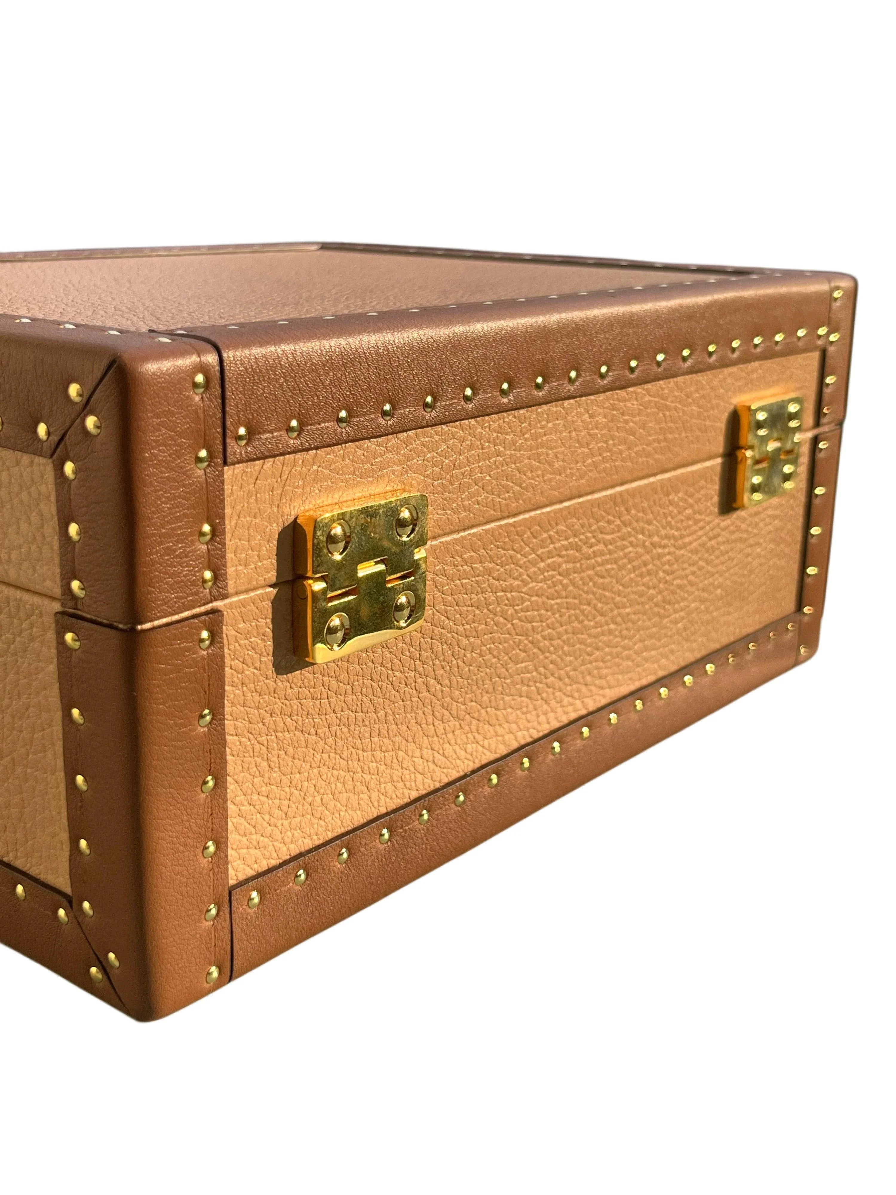 Brown leather jewelry box with gold hardware on a white background