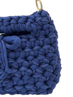 Blue crochet handbag close-up showing woven texture and tie closure
