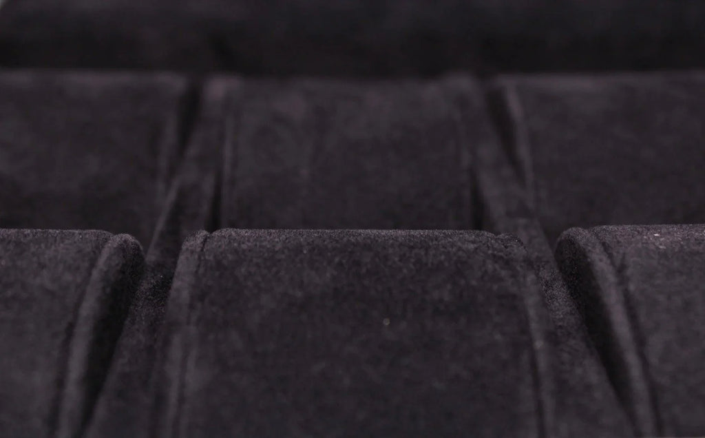 Close-up of black velvet-lined compartment, luxury leather goods storage detail