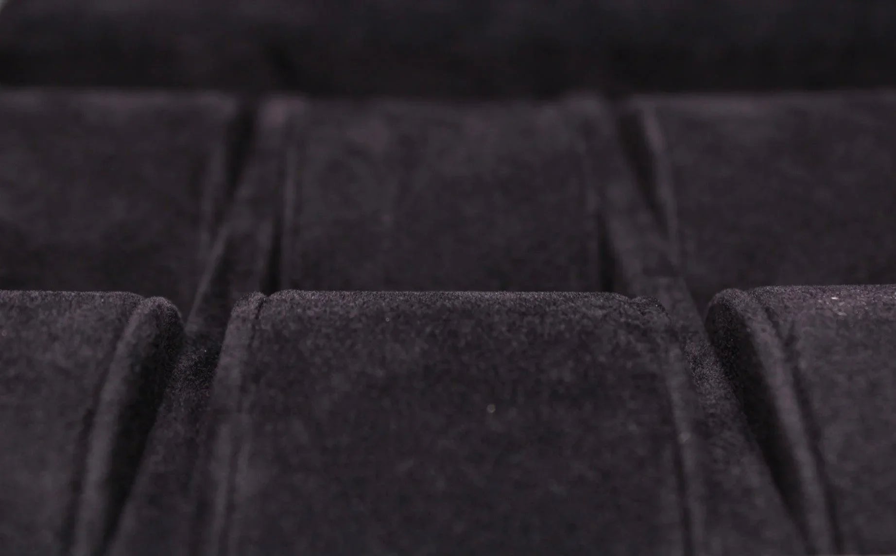 Close-up of black velvet-lined compartment, luxury leather goods storage detail