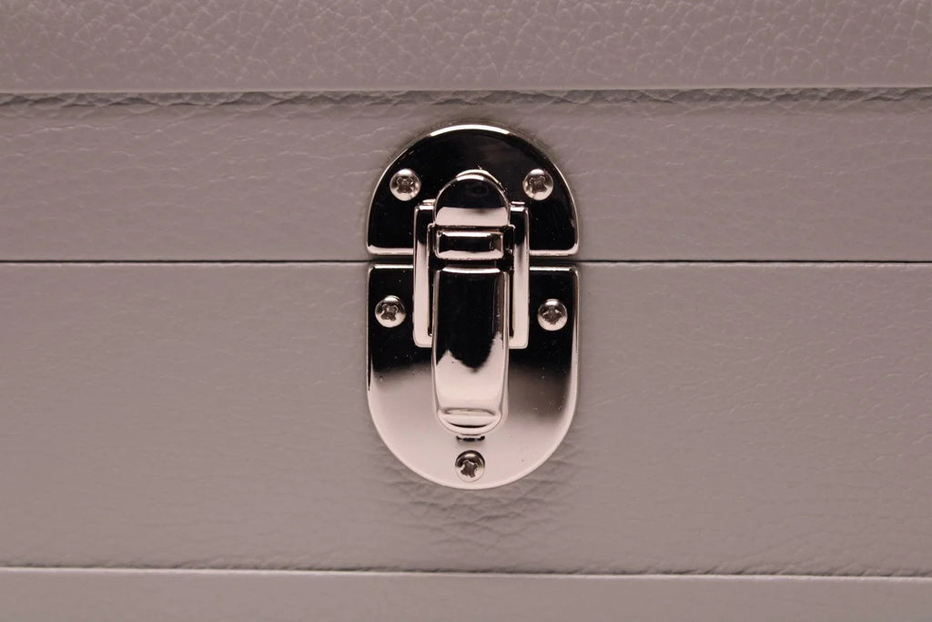 Close-up of silver latch on textured grey leather box