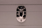 Close-up of silver latch on textured grey leather box