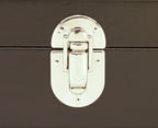 Close-up of a silver metal clasp on a black leather box