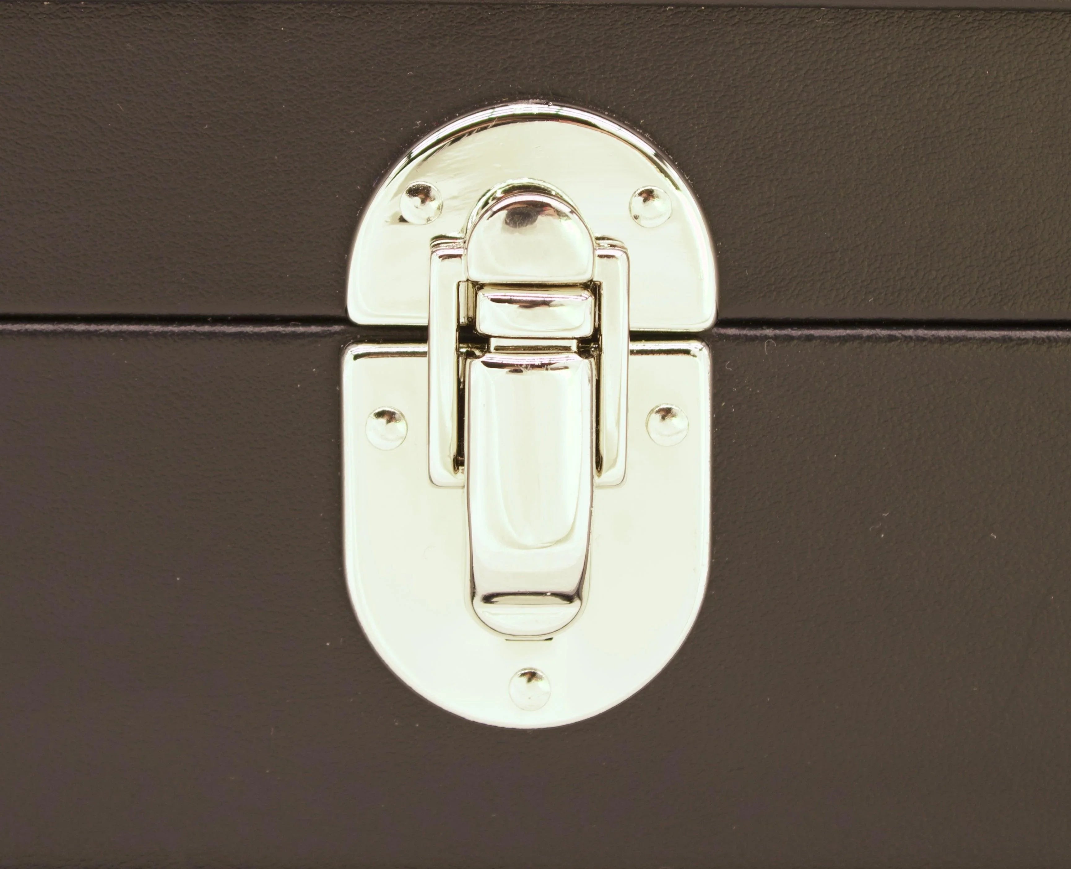 Close-up of a silver metal clasp on a black leather box