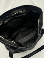 Leather tote bag carried by handle, front view
