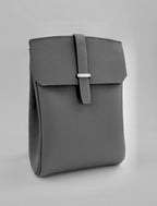 Gray leather bag with a buckle on a light gray background