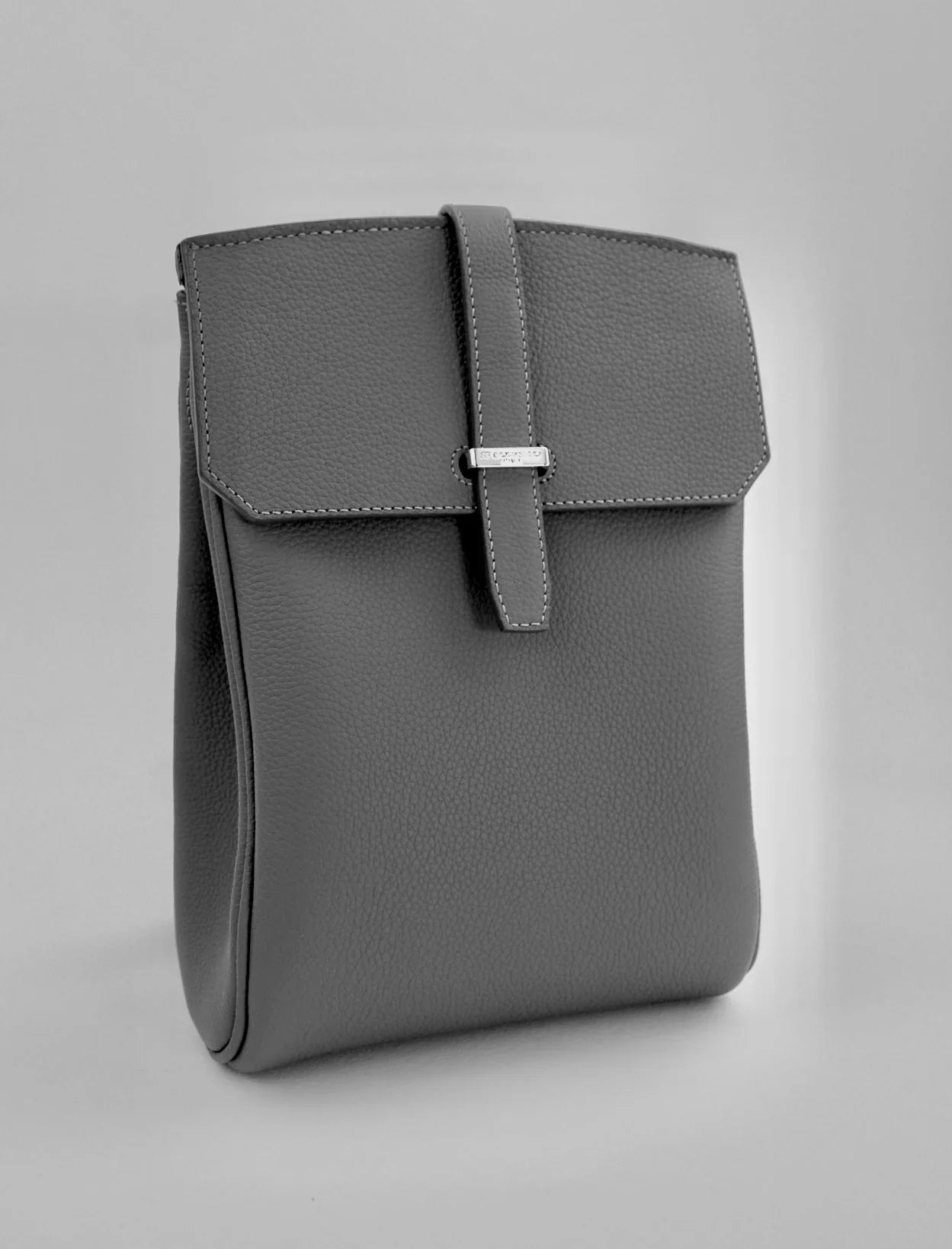 Gray leather bag with a buckle on a light gray background