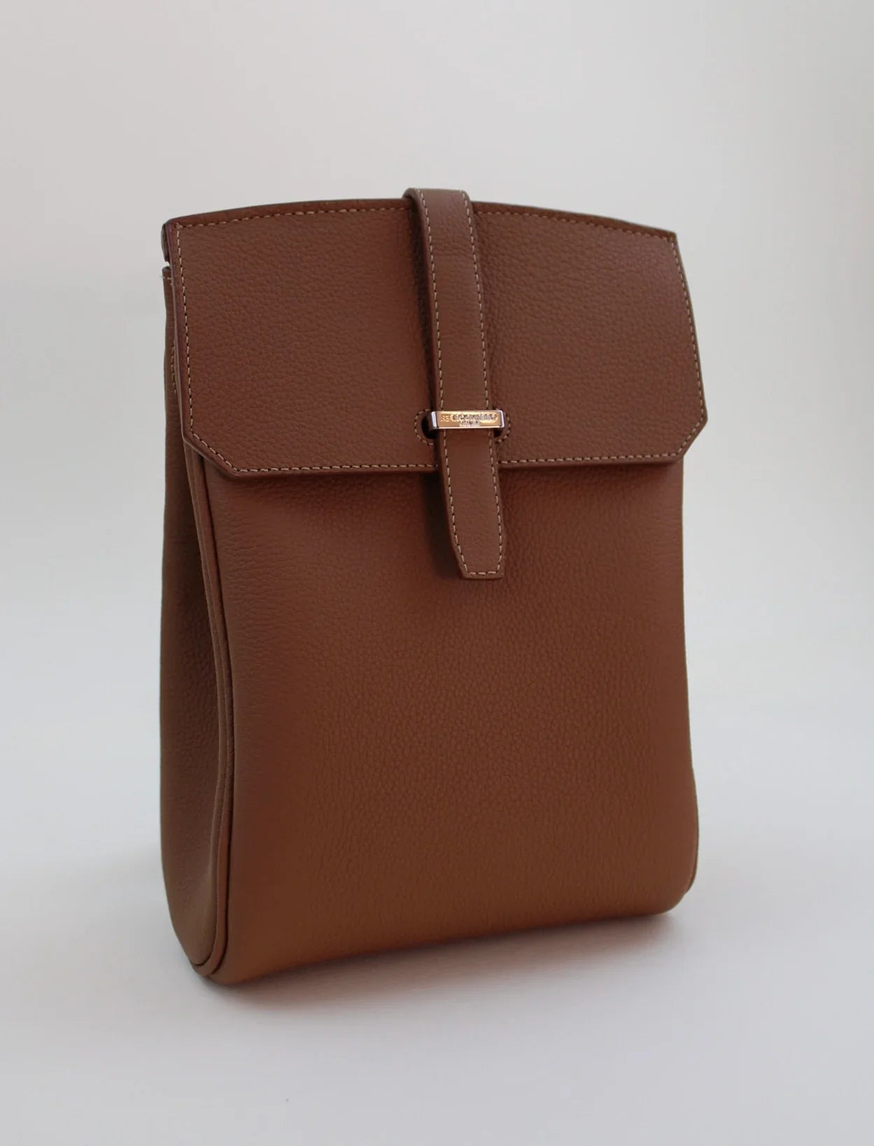 Brown leather bag with a strap on a white background
