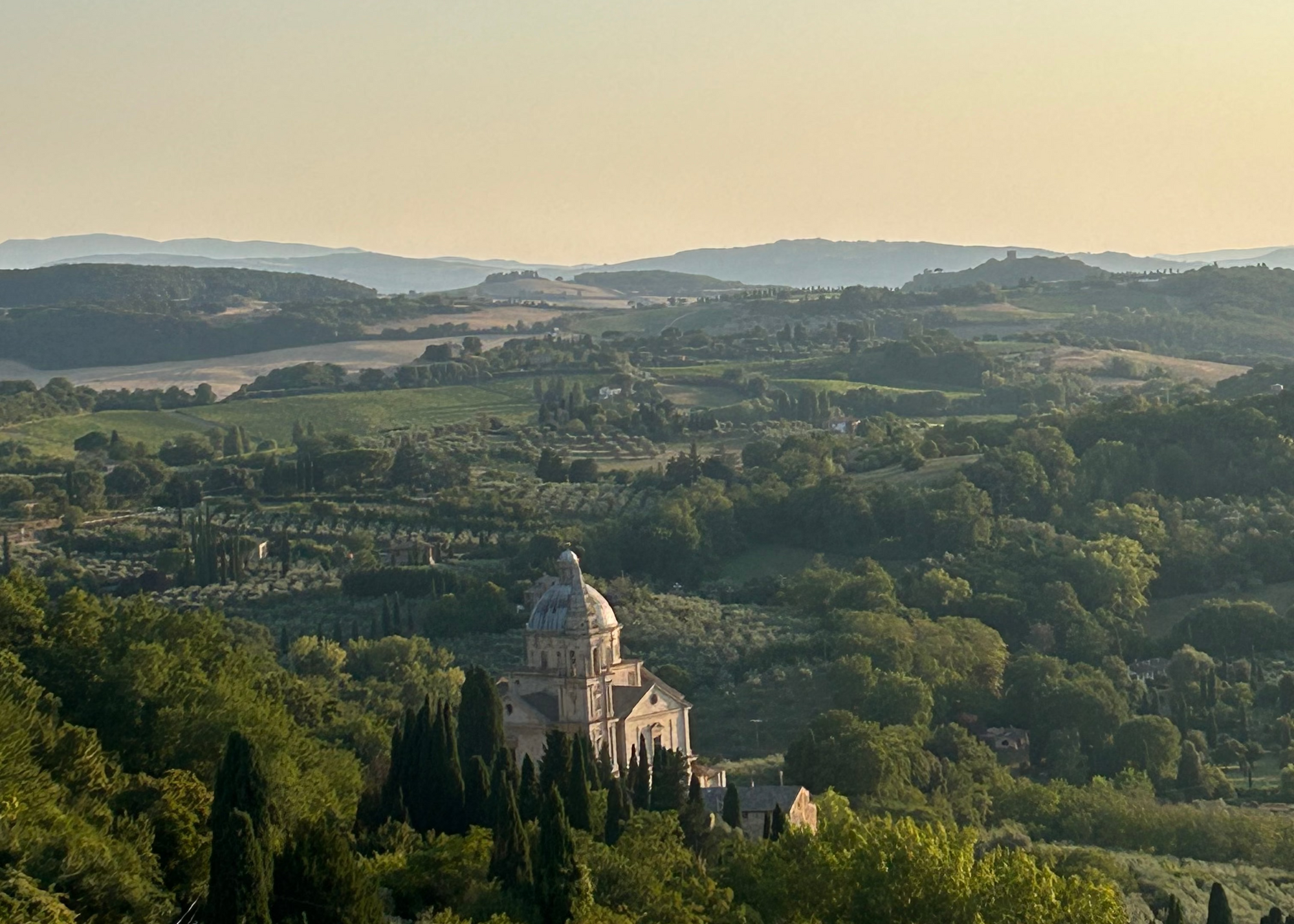 Village nestled in a valley surrounded by greenery with a clear sky