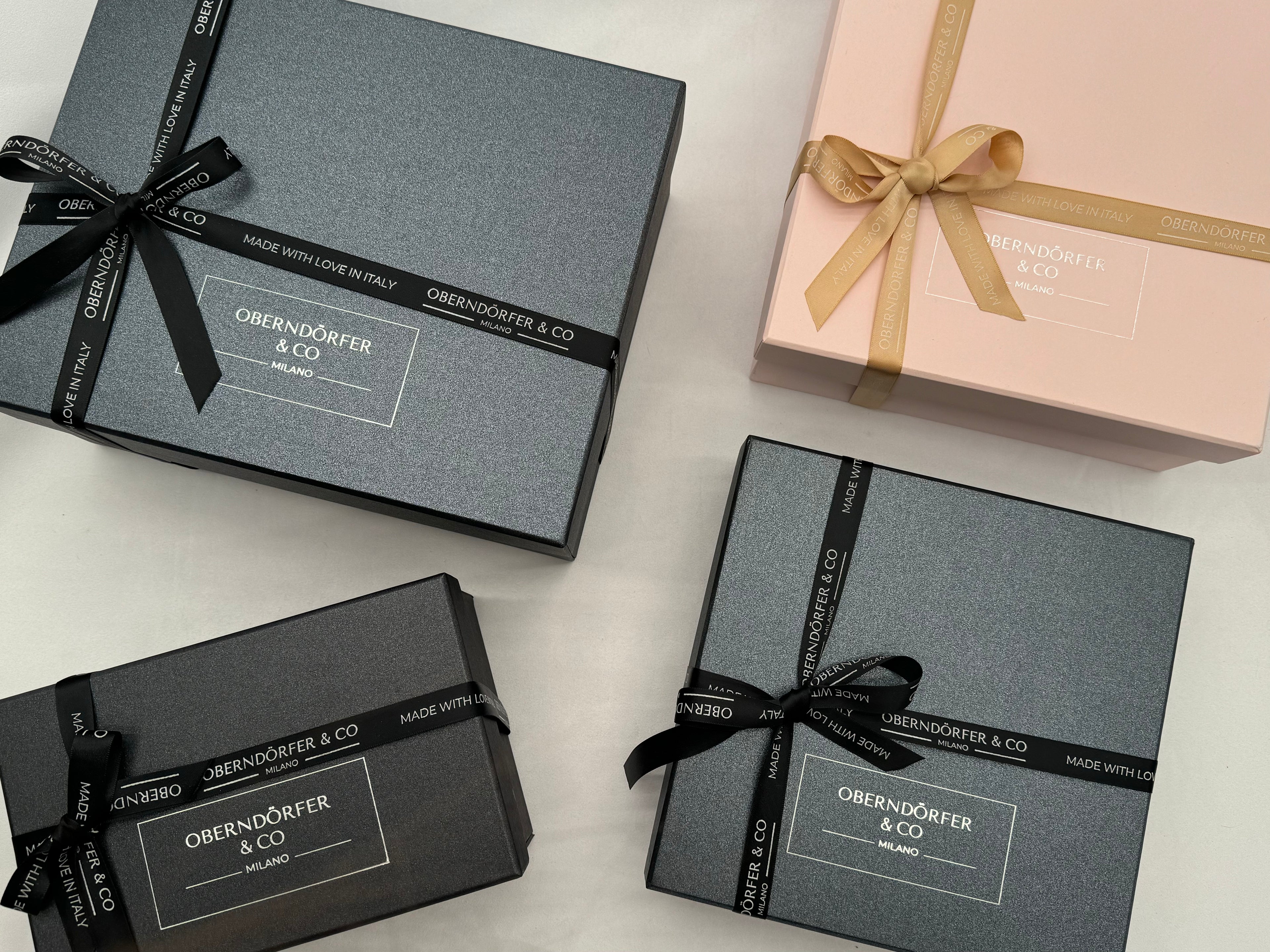 Four Oberndorfer & Co gift boxes with ribbons on a light background