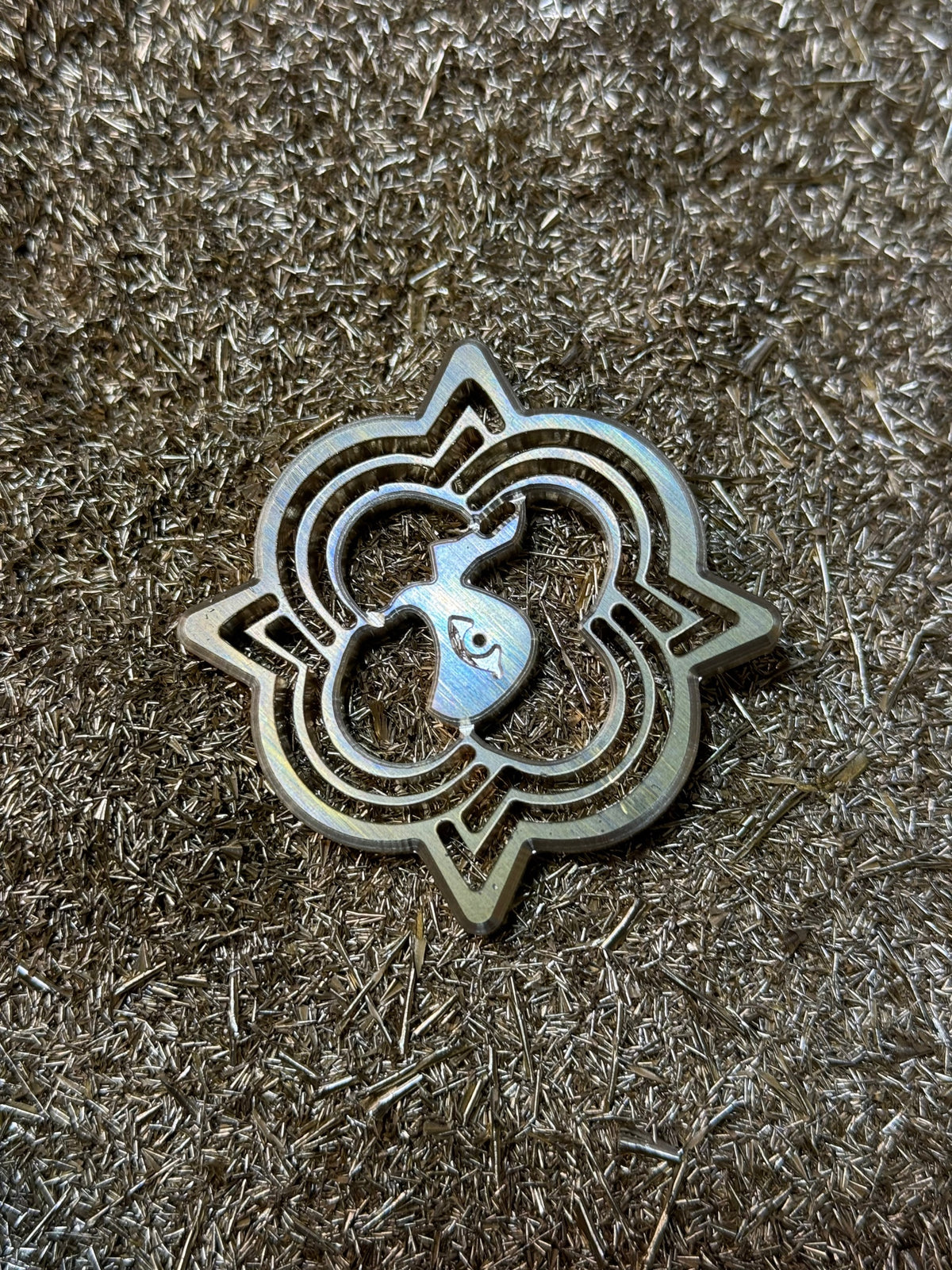 The Oberndörfer Milano emblem cut in solid brass, resting on machined metal shavings