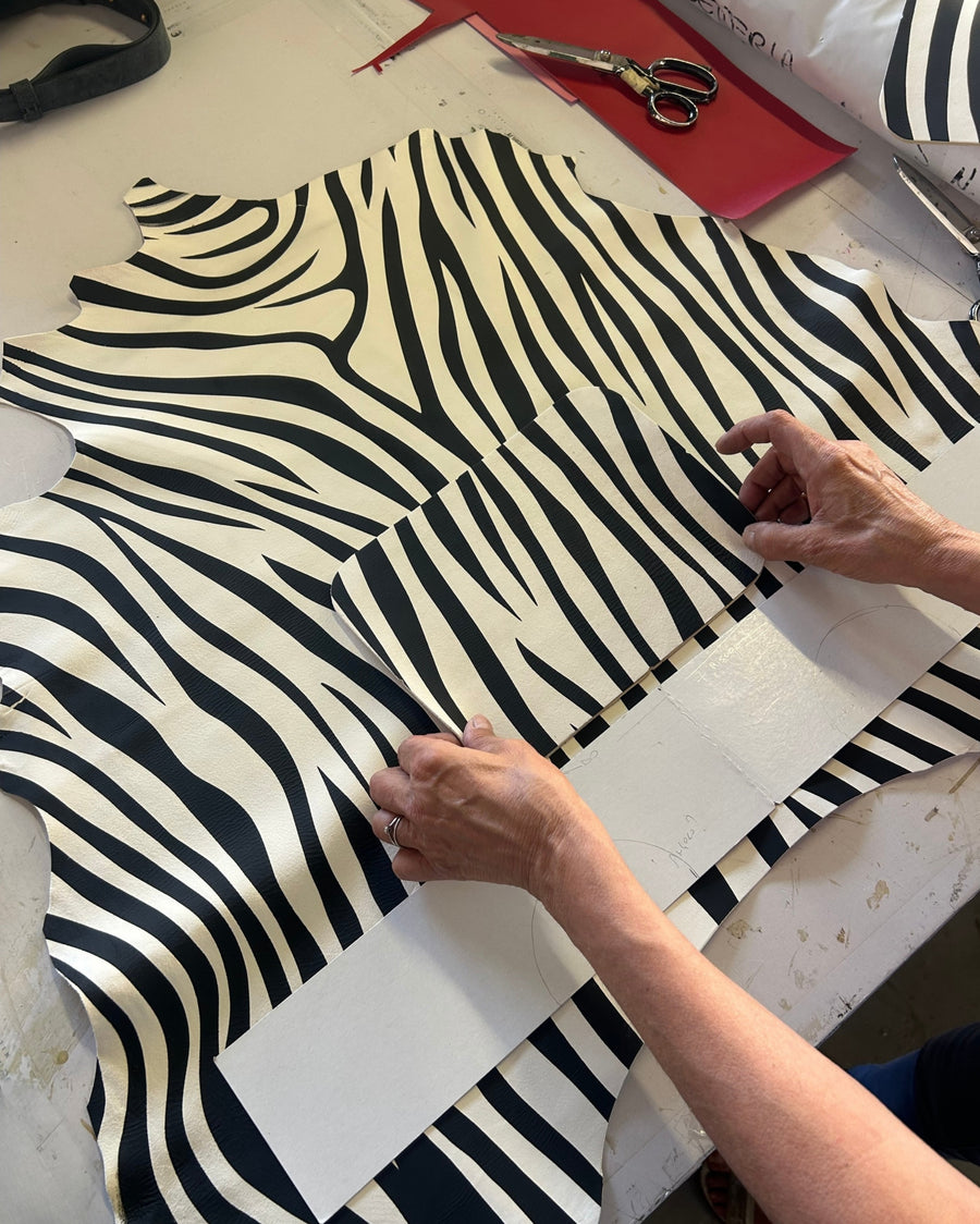 Zebra-print leather being cut by hand in the atelier