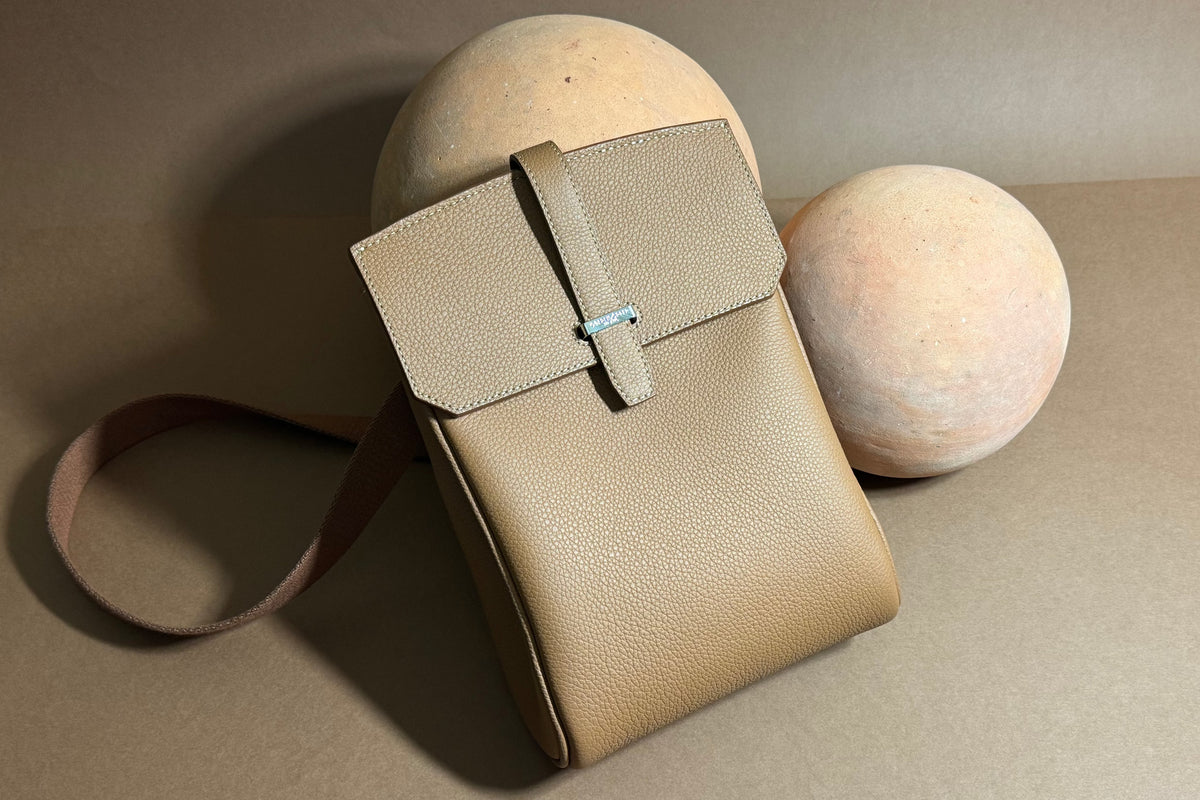 SAC in grained leather resting on stone spheres