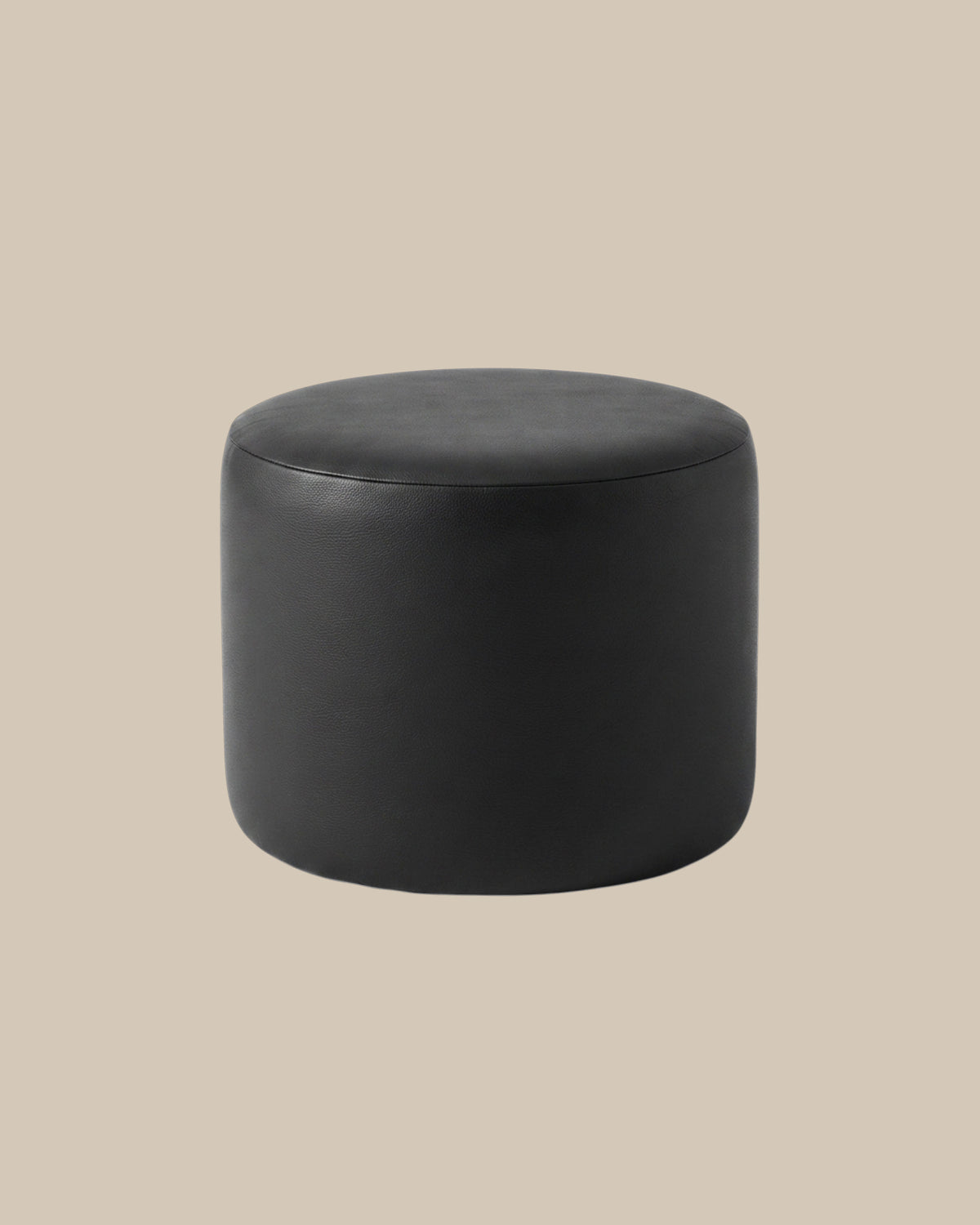 Round black Italian leather pouf on a warm beige ground - Oberndörfer Milano
