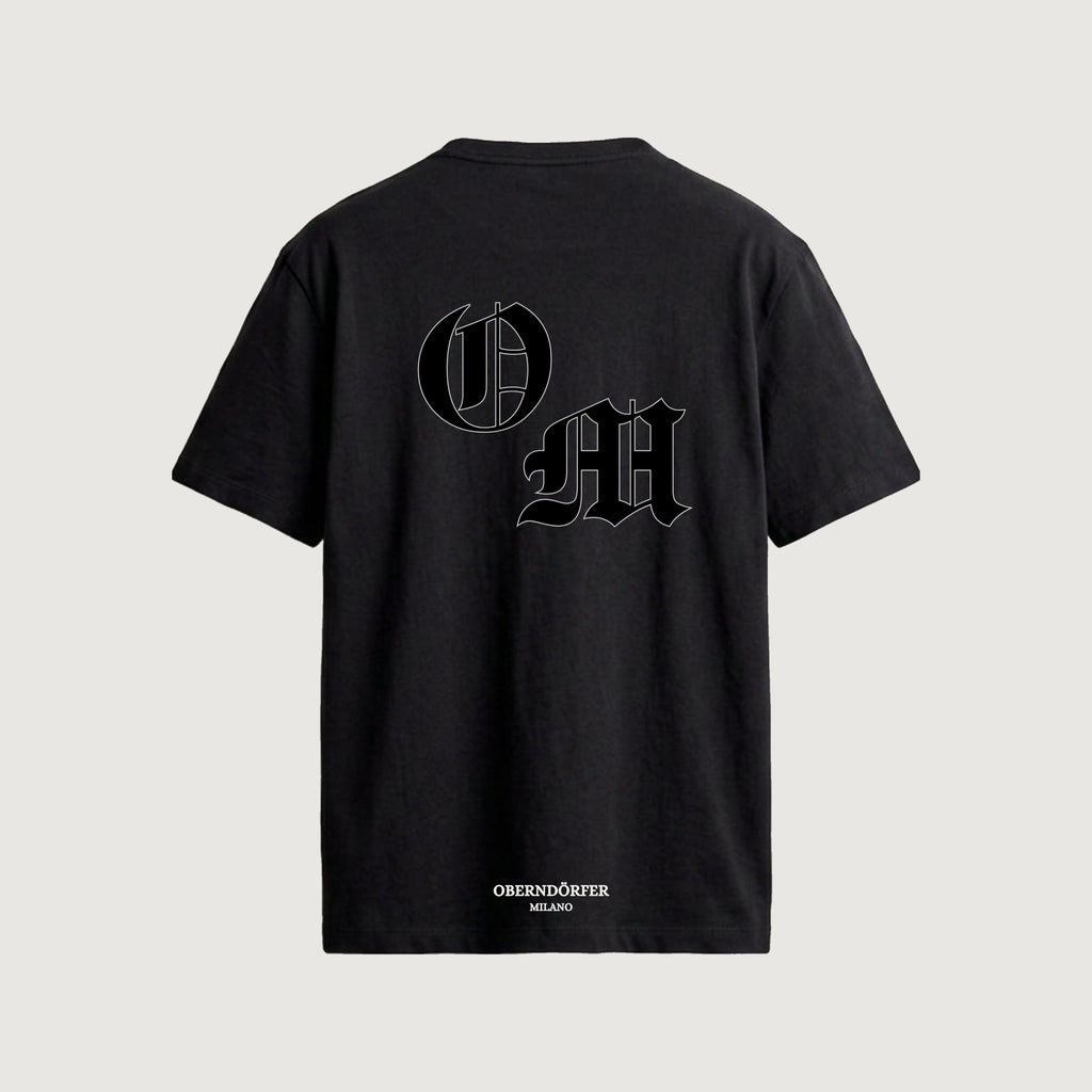 The Initials T-Shirt in black, back, interlocking O and M outlined in blackletter
