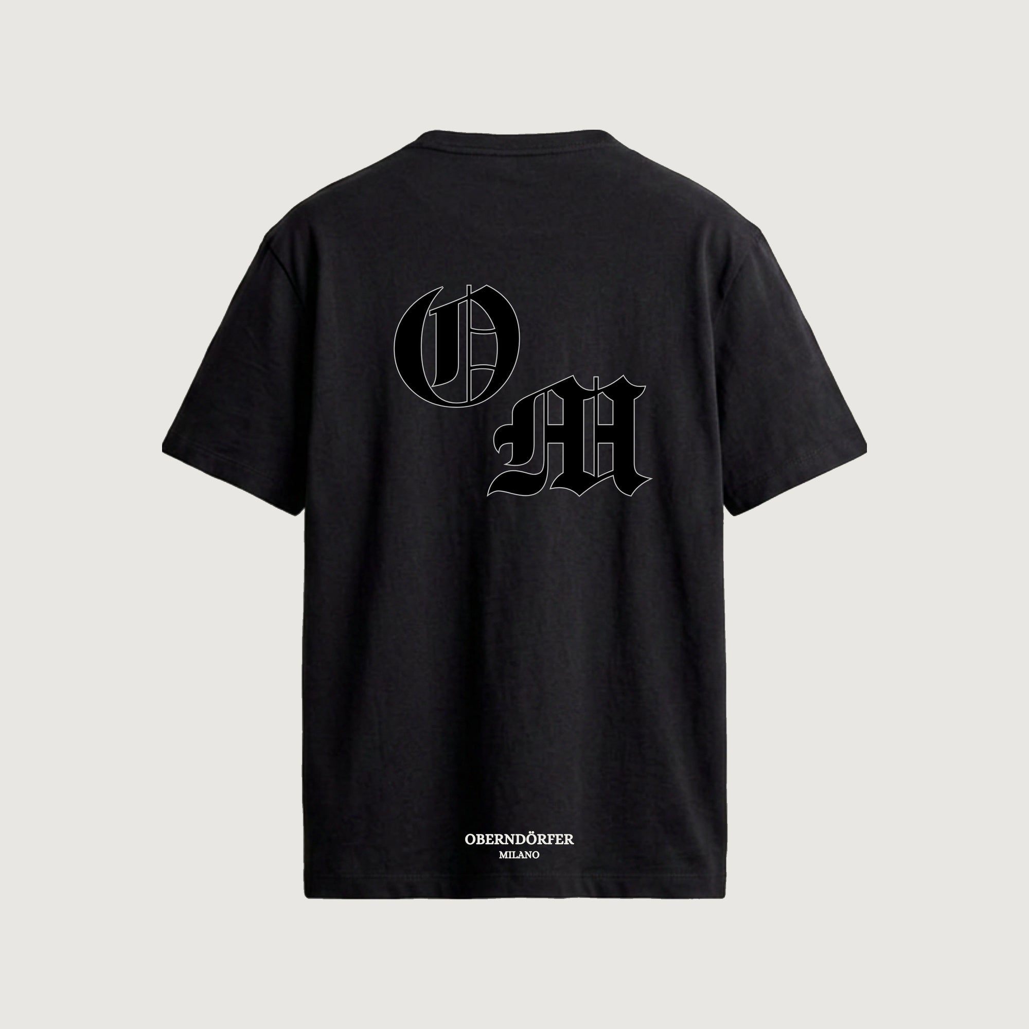 The Initials T-Shirt in black, back, interlocking O and M outlined in blackletter
